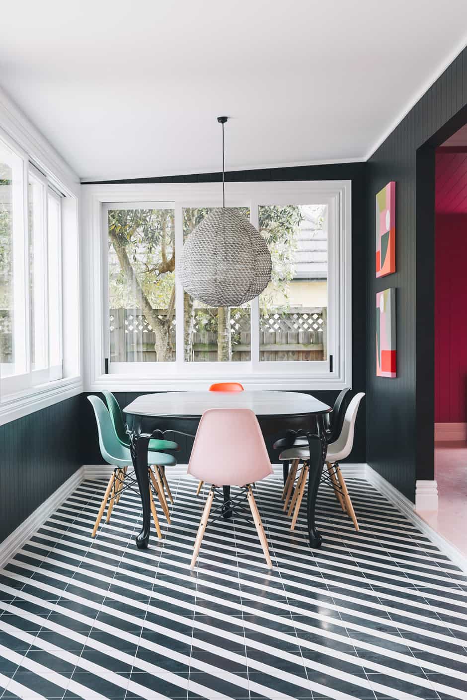 DINING A pendant light by Paris au Mois d’Août from Madder & Rogue, Eames chairs, and a dining table found on Trade Me and painted in Dulux Blackwood Bay (the same shade as the walls) are complemented by Alex’s own artworks, The Twins. She and Daisy are pictured opposite.