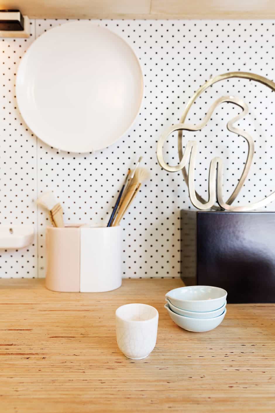 RIGHT Domestic ware from Gidon’s ceramics range sits on the workbench alongside an electroplated brass sculpture and pink-and-white bookends designed for a collaboration between Thing Industries and fashion maven Kate Sylvester.